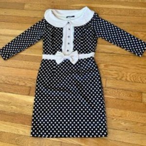 Navy blue polka dot dress with detailed bow. Well fitted to the body.